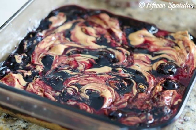 peanut butter and jelly swirled shortbread bars in 8x8 glass pan