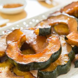 Roasted Acorn Squash Presented on a Lacy White Platter on Wooden Board