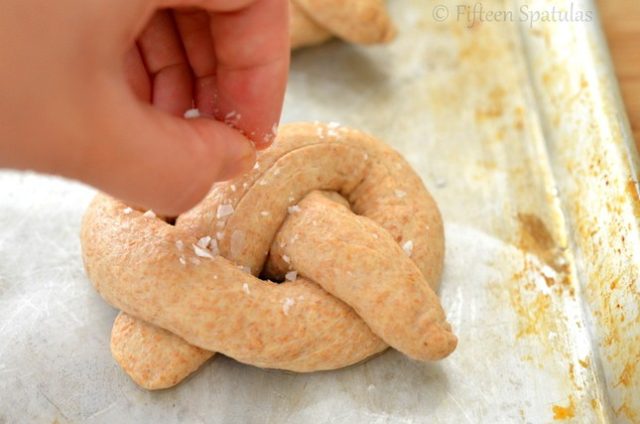 sprinkling whole wheat pretzels with sea salt