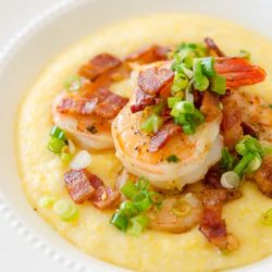 Shrimp and Grits in White Bowl with Scallion Garnish