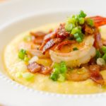 Shrimp and Grits in White Bowl with Scallion Garnish