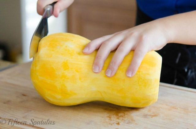 Trimming a whole peeled butternut squash for cubing
