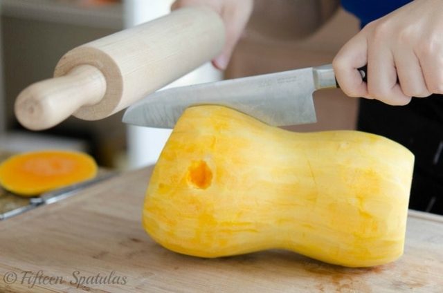 Use a rolling pin to split a whole butternut squash