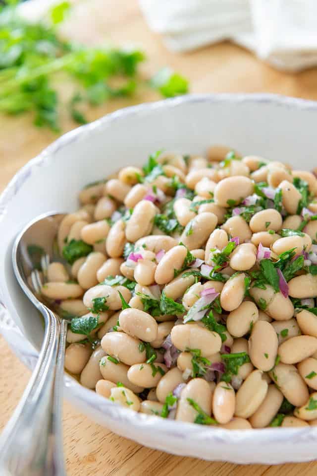 White Bean Salad - in White Low Bowl With Herbs, Lemon, and Red Onion