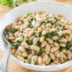 White Bean Salad in White Low Bowl With Herbs, Lemon, and Red Onion