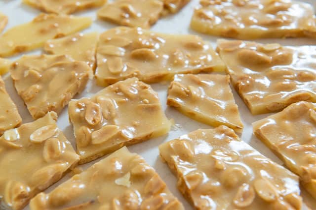 Homemade Peanut Brittle - Broken Into Pieces On Parchment Paper