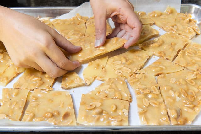 Breaking the Peanut Butter Brittle Into Pieces with Hands