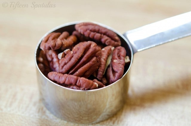 toasted pecans in measuring cup to be minced for praline bacon