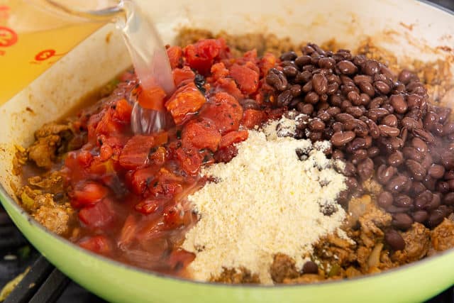 Adding Fire Roasted Tomatoes, Cornmeal, and Black Beans to the Pot