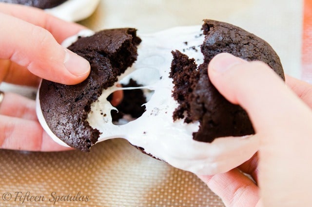 Chocolate Whoopie Pie - Stretched Between Hands to Show Gooey Fluff Filling