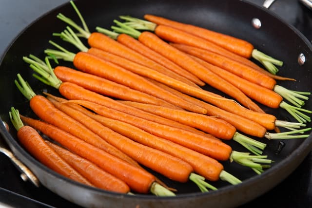 Trimmed Carrots in Nonstick Skillet Ready to Cook Until Tender