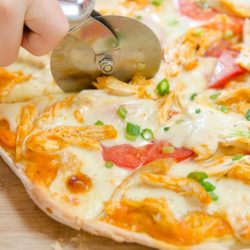 Buffalo Chicken Pizza Cut with a Pizza Cutter on Wooden Board