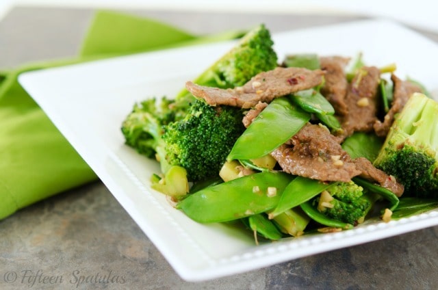 Beef stir fry with broccoli and snap peas in white dish