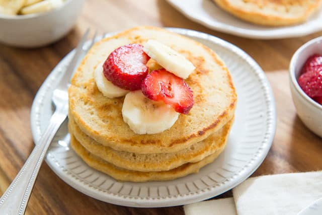 Whole Wheat Pancakes - Served Stacked On a Plate with Berries and Bananas On Top