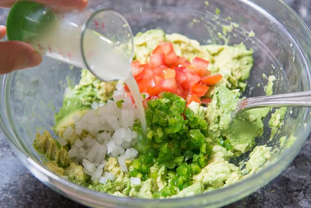 Adding Lime Juice to the Avocados with Tomato and Jalapeno and Onion
