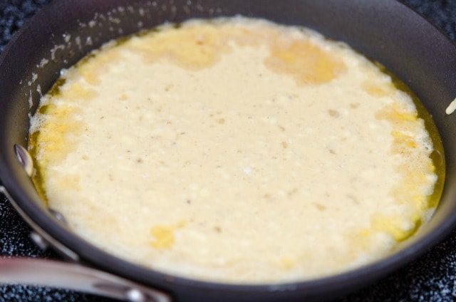 Dutch Baby Pancake Batter Poured Into Melted Butter in Skillet