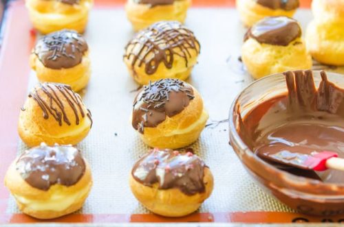 Cream Puffs On a Silicone Mat Filled With Pastry Cream And Chocolate Glazed