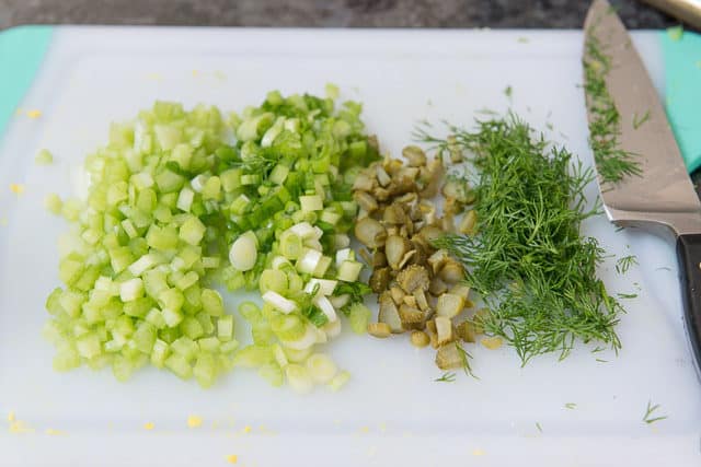 Cut Celery, Scallions, Cornichons, and Dill on Cutting Board