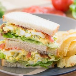 Egg Salad Stuffed Into Sandwiches With Tomato and Lettuce and Served with Chips