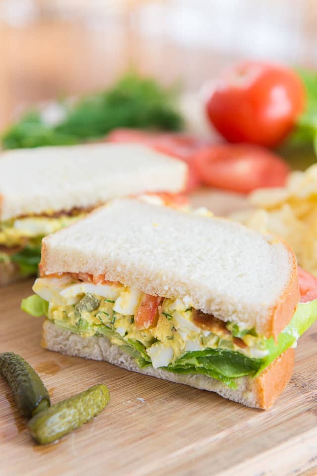 Egg Salad Sandwich on a Wooden Board with Pickle