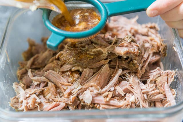 Pouring The Juices Through Strainer Back Into Pulled Pork
