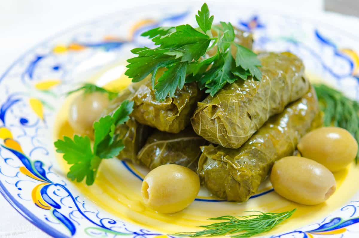Stuffed Grape Leaves In a Pile with Olives