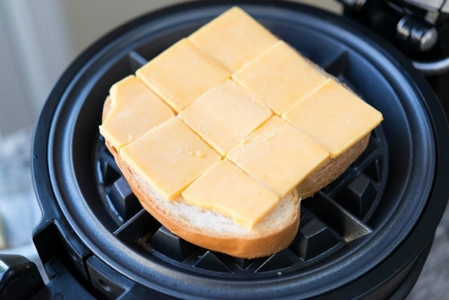 Bread Covered in Cheddar Cheese on Waffle Iron