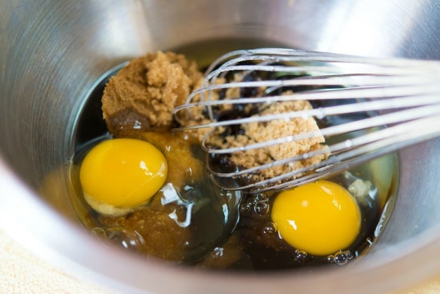 Molasses, Eggs, Brown Sugar, and Oil in a Mixing Bowl with Whisk