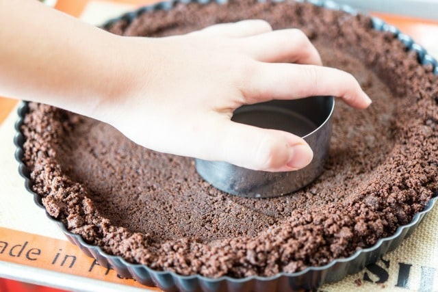 Chocolate Wafer Crumbs Pressed Into Tart Pan with Metal Cup