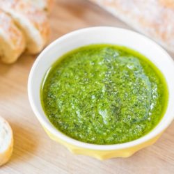 Basil Pesto in Bowl with Baguette Slices on Board