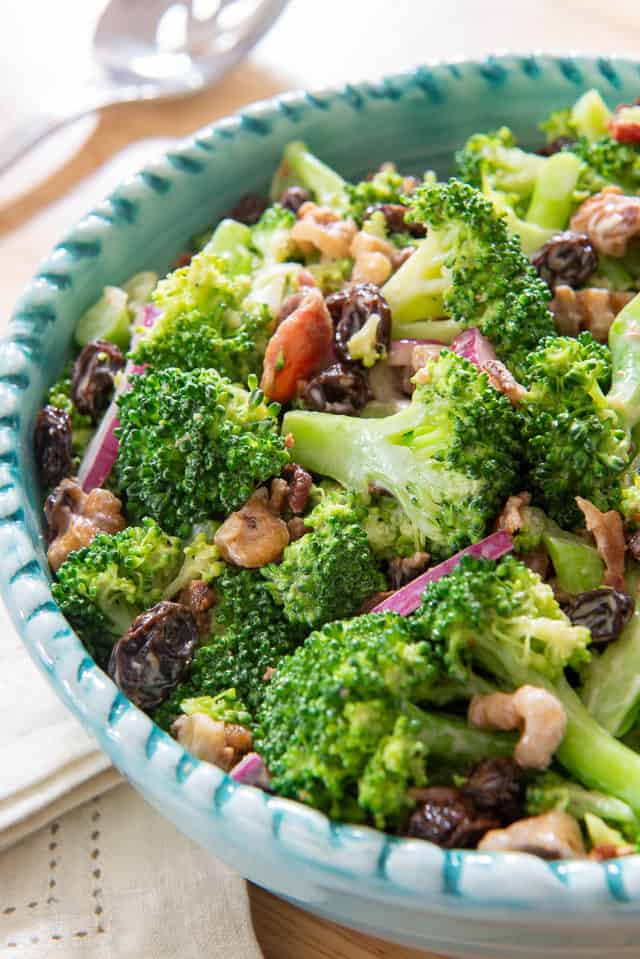 Broccoli Salad - In a Blue Bowl with Red Onion and Raisins