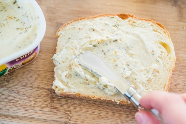 Spreading Garlic Herb Butter on Bread