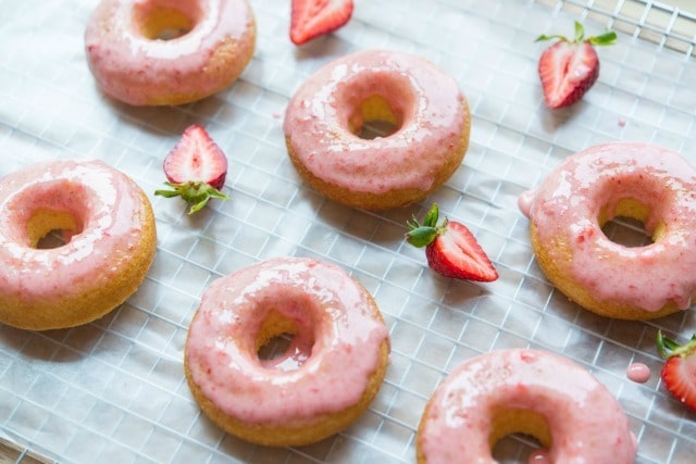 Six Strawberry Glazed Cake Doughnuts on Cooling Rack