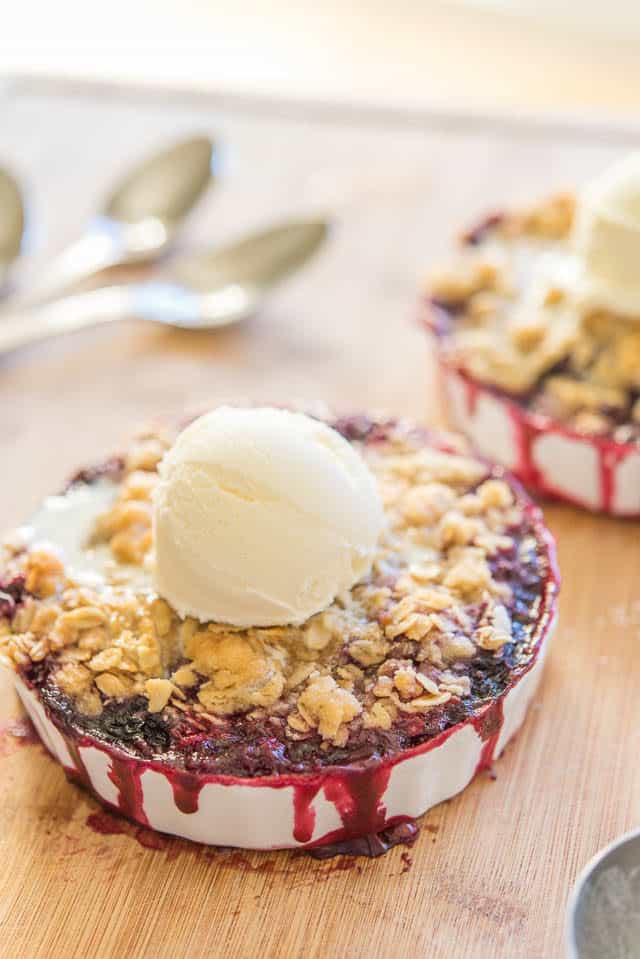 Blackberry Crisp in White Ramekins with Oat Topping and Ice Cream Scoop