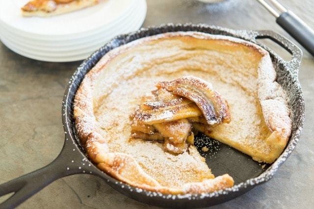 Dutch Baby Pancake Puffed Up in Cast Iron Skillet with Caramelized Bananas in Center