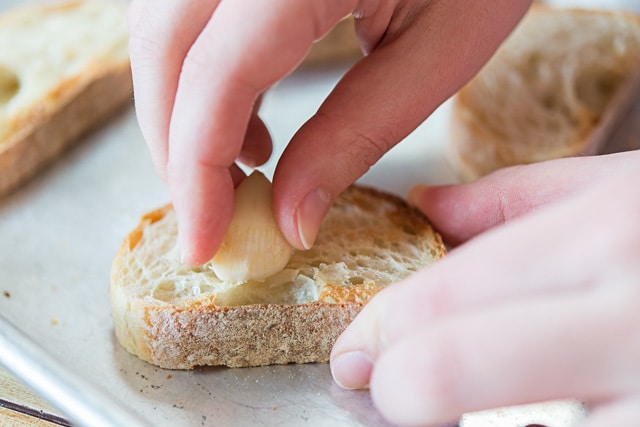 Rubbing Toasted Baguette Slice with Raw Garlic