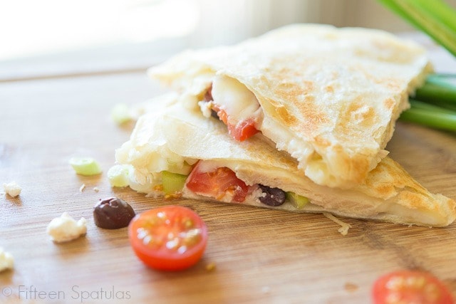 Quesadilla Triangles Stacked on Cutting Board with Greek Ingredient Filling