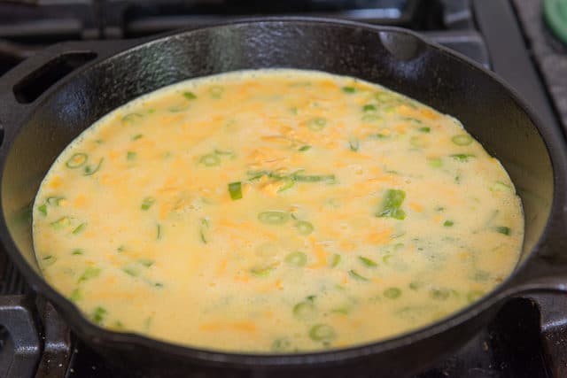 Raw Egg Batter in Skillet with Green Onion and Cheddar Cheese