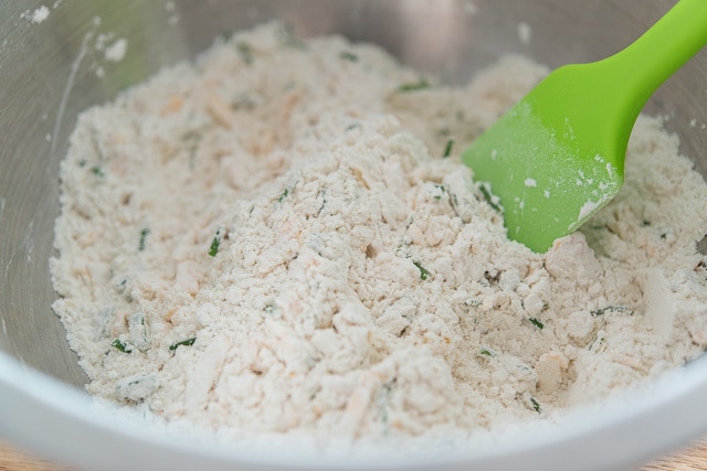 Flour, Leavener, and Other Dry Ingredients in Mixing Bowl with Cheese and Chives Tossed In