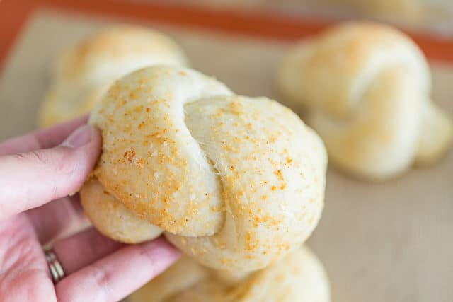 Garlic Knots - Shown about Palm Sized with One Held Up and Some on Tray