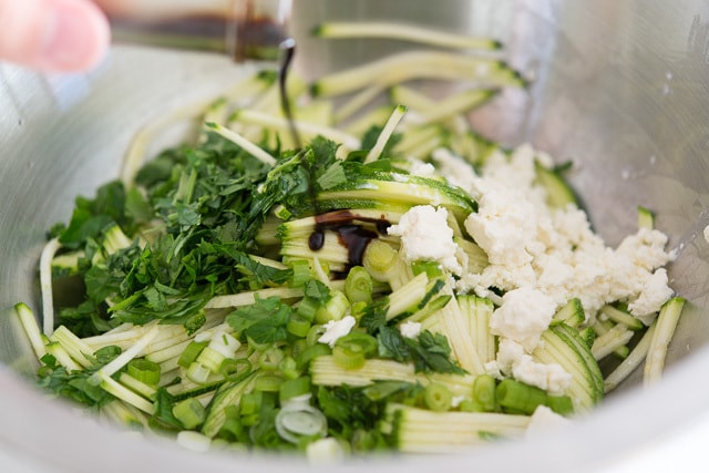 Adding Vinegar to Shredded Zucchini Salad Ingredients