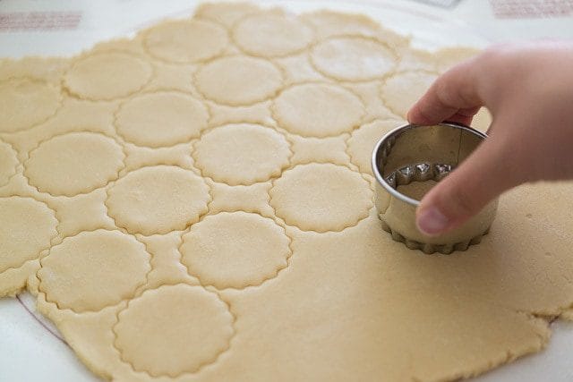 Using Metal Cutter to Cut Circles Of Cut Out Cookies From Counter