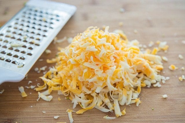 Grated Cheddar Cheese on Wooden Board