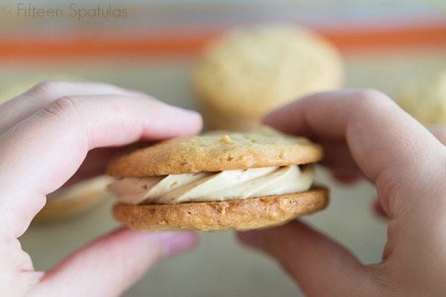 Peanut Butter Sandwich Cookies - With Piped Buttercream Filling and Hands Holding It Up