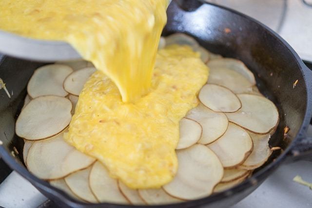Pouring Egg Frittata Mixture Over Sliced Potatoes