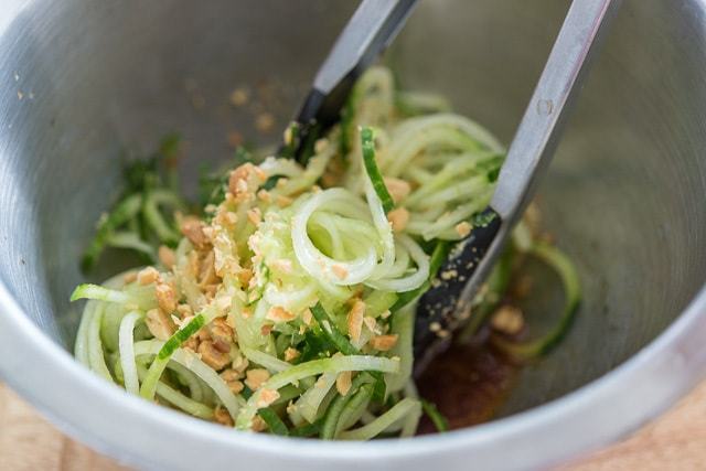 Tossing the Cucumber Noodle Salad in Mixing Bowl with Peanuts