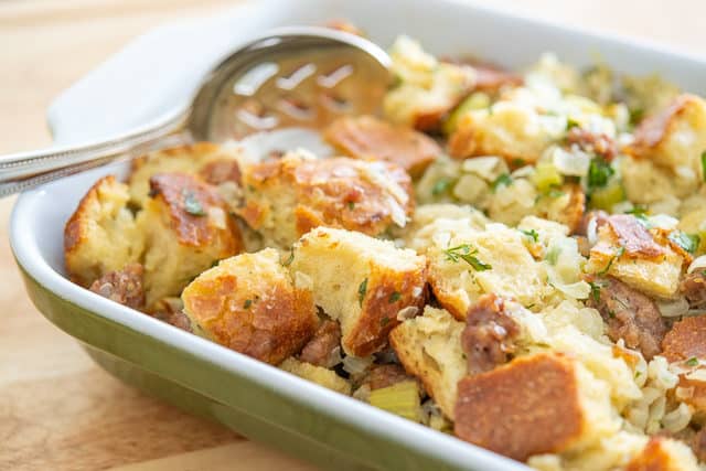 Best Thanksgiving Stuffing - Presented in a Green Casserole Dish with spoon