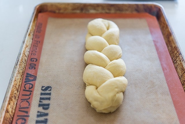 Braided challah bread dough on silicone mat