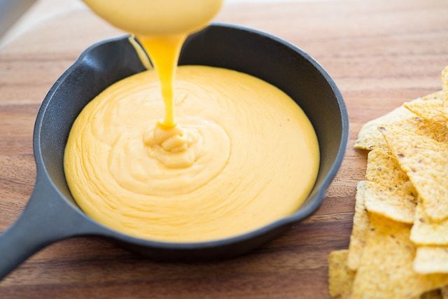 Pouring the Homemade Nacho Cheese Sauce into Cast Iron Skillet