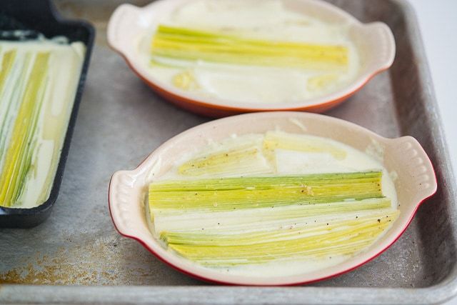 Halved Leeks Sitting in Dairy in Oval Dishes